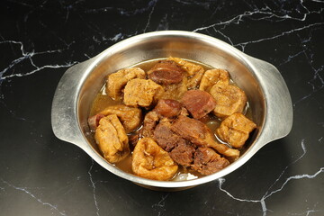 Traditional boiled pork with fried tofu in gravy sauce serving in the bowl. Famous Chinese ancient menu in restaurant. 