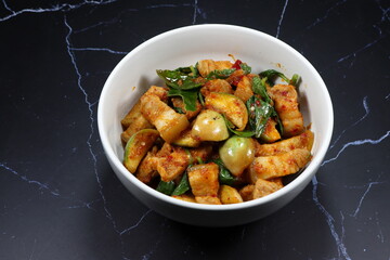 Traditional spicy fried eggplant with basil and streaky pork serving in the bowl. 