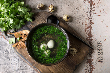 a bowl of chicken broth with herbs and quail eggs on the table