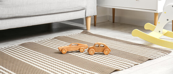 Wooden toy cars on stylish carpet in children's room - Powered by Adobe