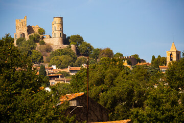 Scenic view of ruins of ancient fortified castle of Grimaud on hill dominating residential houses...
