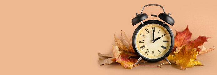 Alarm clock and autumn leaves on brown background with space for text - Powered by Adobe