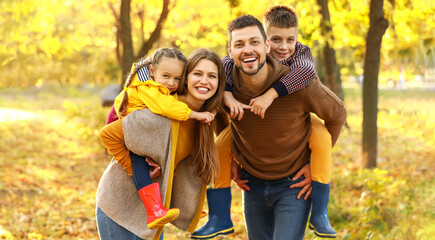 Happy young family resting in autumn park