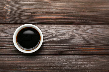 Bowl of soy sauce on dark wooden background