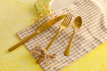 Fototapeta na wymiar Table setting with flower decor on yellow background