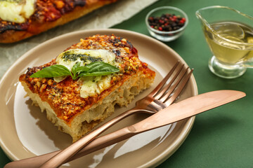 Plate with piece of tasty Italian pie on green background, closeup