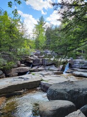 Fototapeta na wymiar Diana's Baths waterfall on rocks with trees in New Hampshire