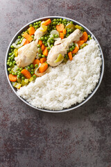 Pollo Arvejado or Peas and Carrots Chicken Stew is a classic Chilean comfort dish closeup in the plate on the table. Vertical top view from above