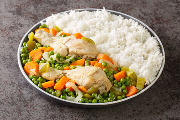 Chilean food Pollo arvejado chicken stew with carrots and green peas served with rice close-up in a plate on the table. Horizontal