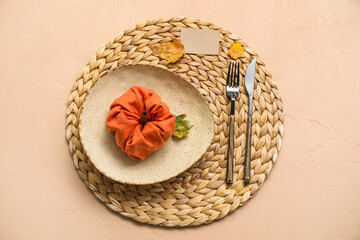 Stylish table setting with pumpkin made of napkin on beige background