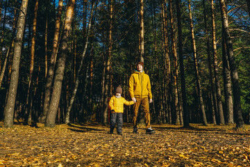 Fototapeta premium Father and son having fun in autumn forest.