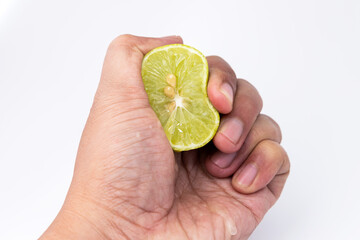Hand squeezing lime sliced isolated in white background. Fresh lemon sour fruit many vitamin C ingredient for  healthy lifestye food.