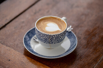 Close up photo of latte coffee on wooden table.