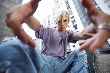 A teenage boy catching camera while posing in urban exterior.