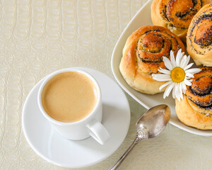 cup of coffee with milk and buns with poppy seeds for breakfast
