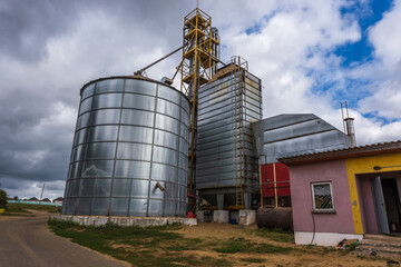 row of agro silos granary elevator with seeds cleaning line on agro-processing manufacturing plant...