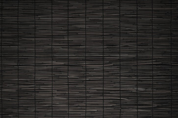 Close up of black bamboo screen. Blind made of split bamboo or reeds fastened together with thread.