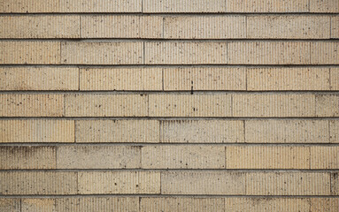 Beige brick tile wall background. Vertically striped patterned brick wall texture.
