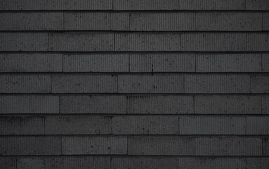 Black brick tile wall background. Vertically striped patterned brick wall texture.