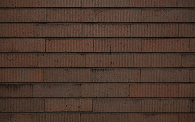 Dark brown brick tile wall background. Vertically striped patterned brick wall texture.