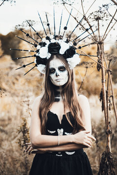 Closeup portrait of Calavera Catrina in black dress. Sugar skull makeup. Dia de los muertos. Day of The Dead. Halloween.