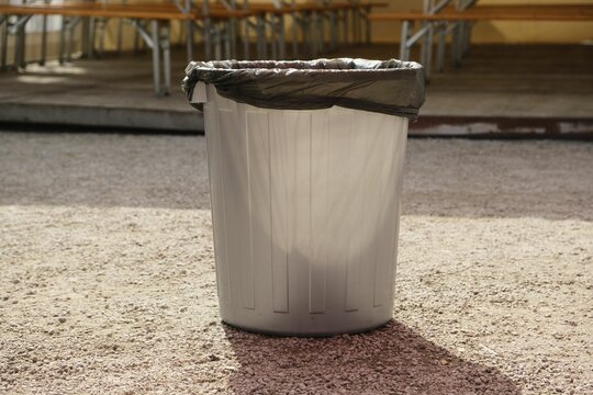 Closeup Of A Garbage Bin With A Black Plastic Bag Inside On A Sunny Day