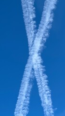 Kondensstreifen am wolkenlosen Himmel ergeben eine Form die aussieht wie ein X.
contrails, Wolken,...