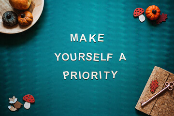 Self-care quotes, make yourself a priority words on green background flat lay. Self-care text...
