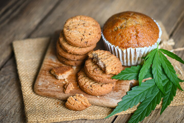 Cannabis food cookies with cake chocolate cannabis leaf marijuana herb on wooden and dark...