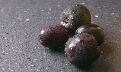 Jambul or Jamun (Syzygium cumini) in yellow bowl isolated on textured background.