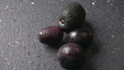 Jambul or Jamun (Syzygium cumini) in yellow bowl isolated on textured background.