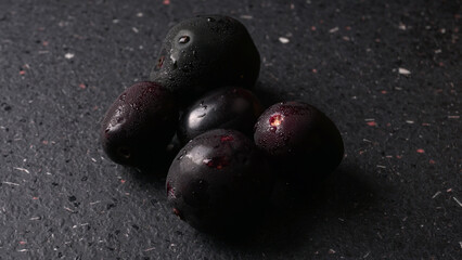 Jambul or Jamun (Syzygium cumini) in yellow bowl isolated on textured background.