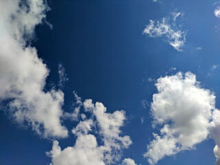 Background bright blue sky with white fluffy clouds on a summer day