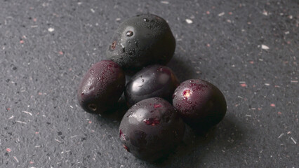 Jambul or Jamun (Syzygium cumini) in yellow bowl isolated on textured background.
