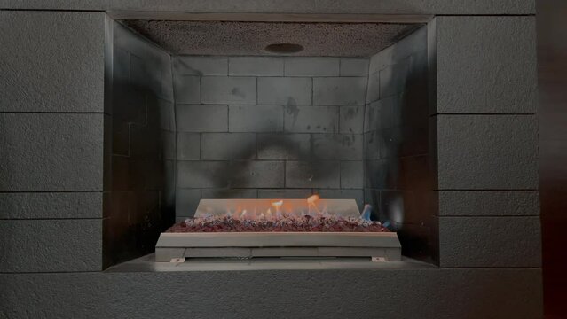 Grey briks fireplace with burning fire
