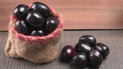 Jambul or Jamun (Syzygium cumini) isolated on wooden background
