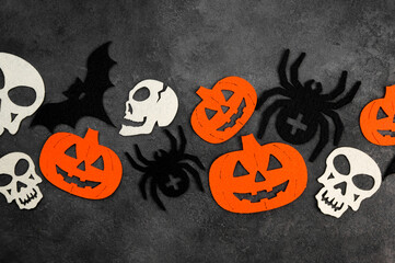 Halloween flatlay with felted attributes.Skulls,bats,spiders,pumpkins on dark concrete background.