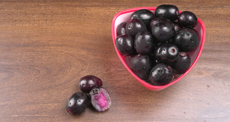 Jambul or Jamun (Syzygium cumini) isolated on wooden background