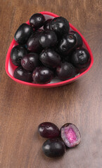 Jambul or Jamun (Syzygium cumini) isolated on wooden background