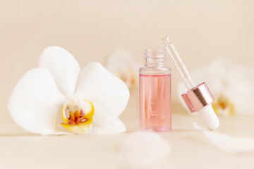 Fototapeta na wymiar Opened Dropper Bottle near white orchid flowers on light beige close up. Skincare beauty product