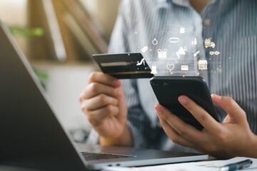 women's hands using smartphones with accessories icons and holding credit card for online shopping at home, Online shopping, e-commerce, internet banking, and spending money.Black Friday