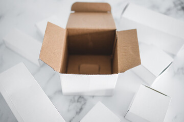 group of white plain delivery parcels with an open and empty one in the middle, online shopping and shipping business concept