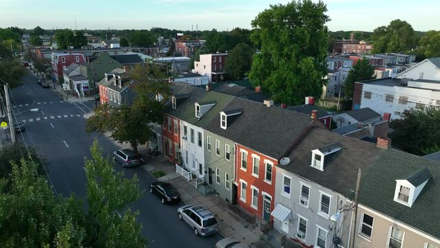 Aerial view of city housing in USA. Golden hour light in summer. Apartment houses along quiet street.