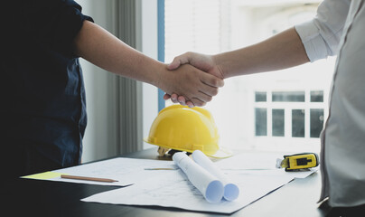 Shake a hand, Team of engineers and architects, working team, meeting, discussing construction and drawing construction plans, printing, writing on-site construction sites. Home design concept