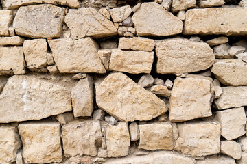 Beige stone wall background. Beige stone wall background. The texture of the stone wall.