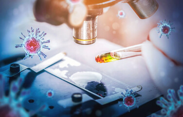 Scientist in biohazard protection clothing analyzing covid 19 sample with microscope and holding...