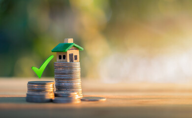 Mortgage and loan approved concept:  house on a coin pile. planning savings money of coins to buy a...