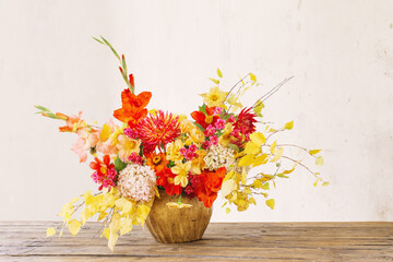 autumn bouquet with red and yellow flowers in ceramic vase on white  background