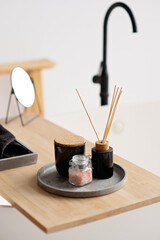 Spa treatment composition on wooden table, diffuser candles and pink sea salt for meditation and relaxation. Soft selective focus.