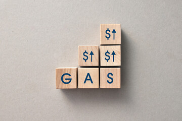 wooden cubes with arrows and dollar signs and the inscription: gas. A symbol of rising gas prices